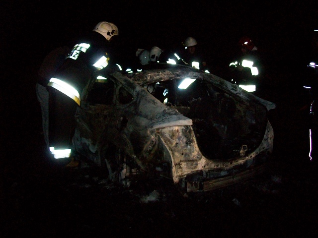 Płonący samochód Ford Mondeo na łące.