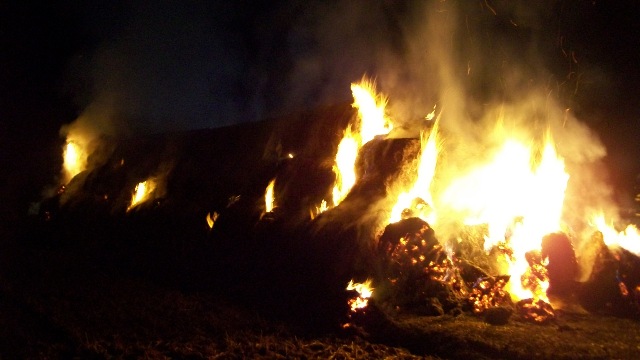 Płonąca prasa, słoma, ściernisko oraz stóg siana