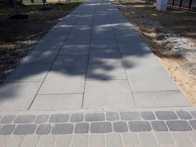 Na ścieżce za budynkiem dworca trwa układanie betonowych płyt